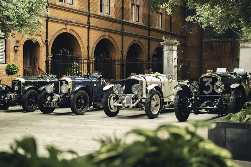 Four vintage Bentleys lined up before a brick arcade, Countdown to Le Mans Classic