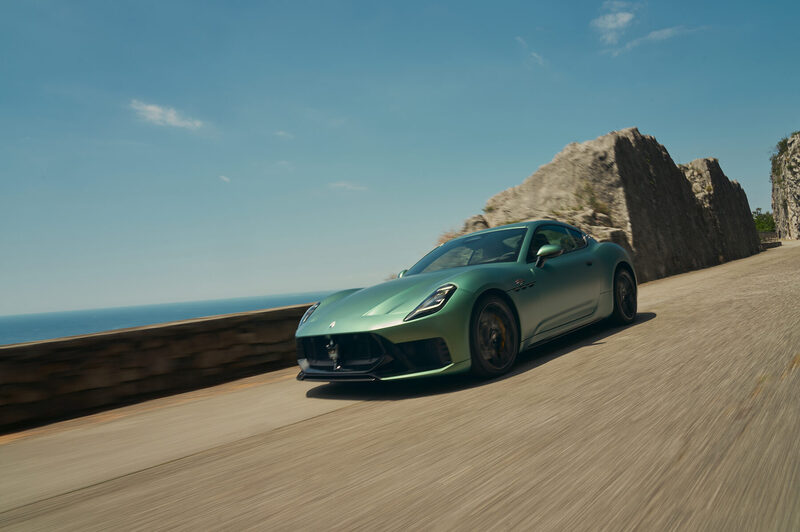 Maserati GranTurismo in green on the Trieste coast road, sea and rock wall behind