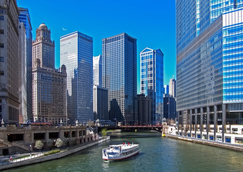 Chicago River with downtown towers and a passing ferry
